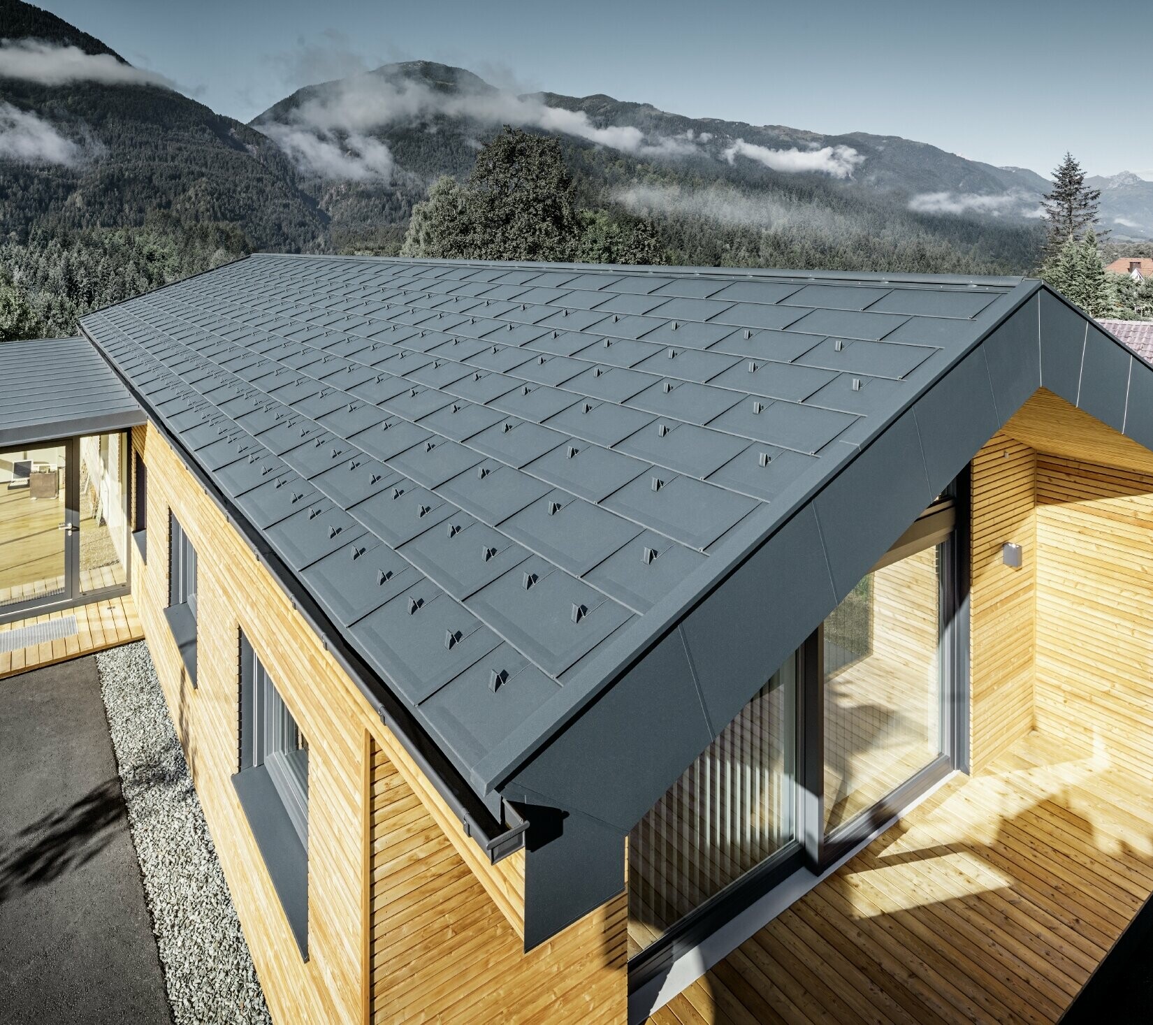 New office building of Holzbau Faltheiner with a larch wood façade, large windows and a PREFA roof in anthracite.