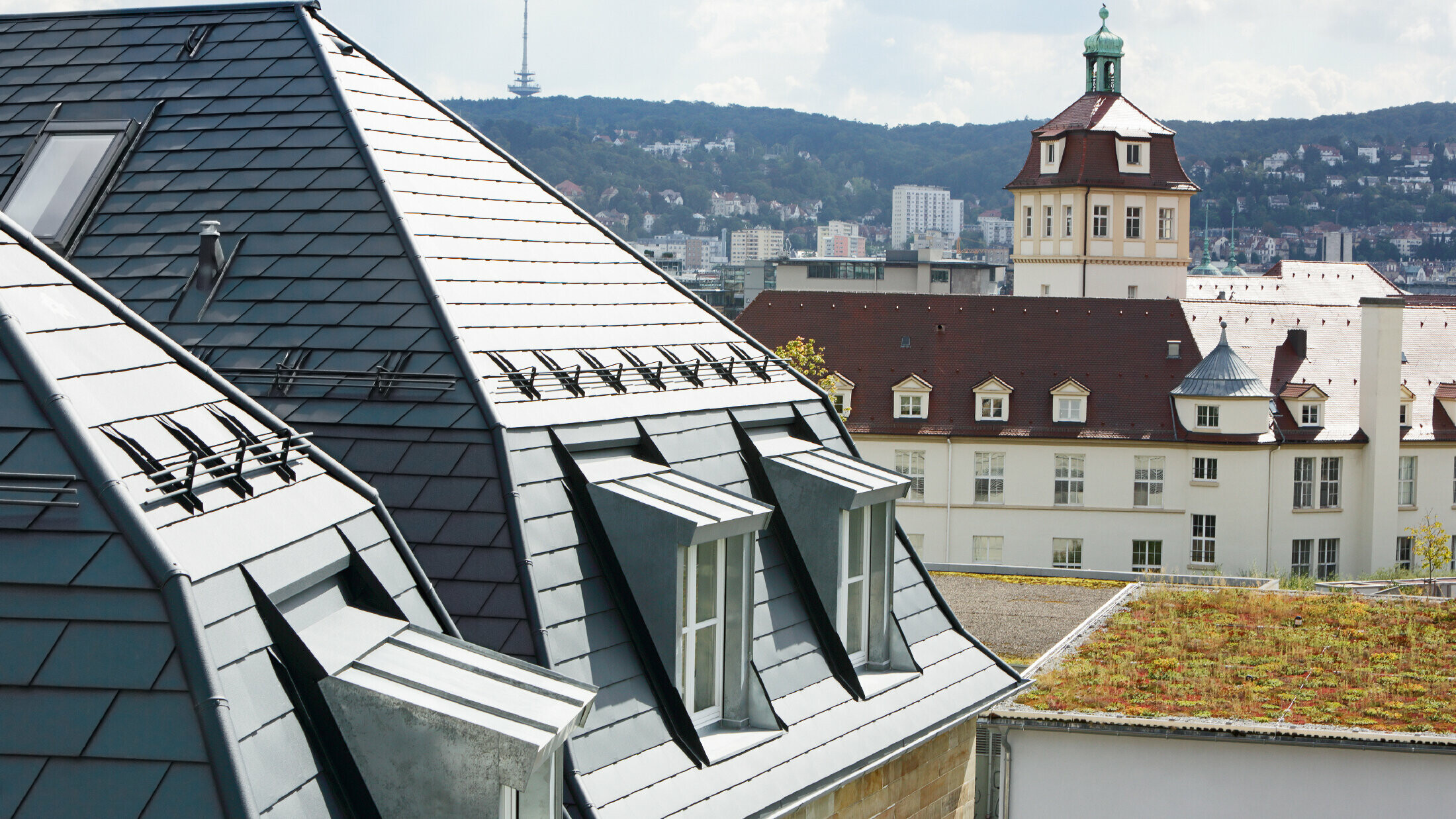 Old town house in Stuttgart with pitched roof and many dormer windows, roofed with PREFA aluminium shingle in P.10 anthracite