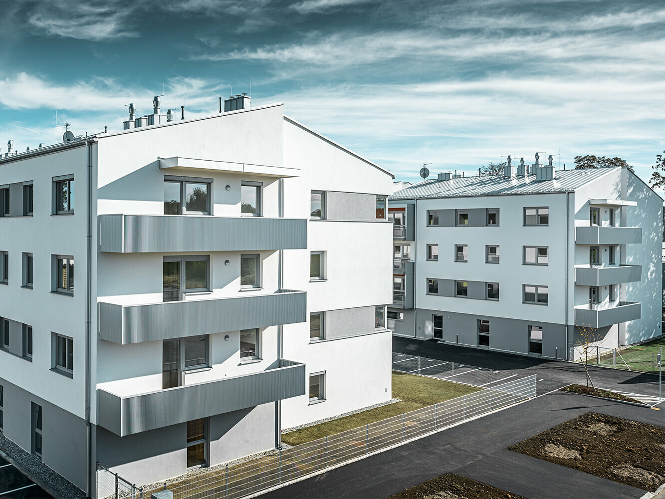 Modern apartment complex with white façade and balconies with PREFA serrated profile in metallic silver