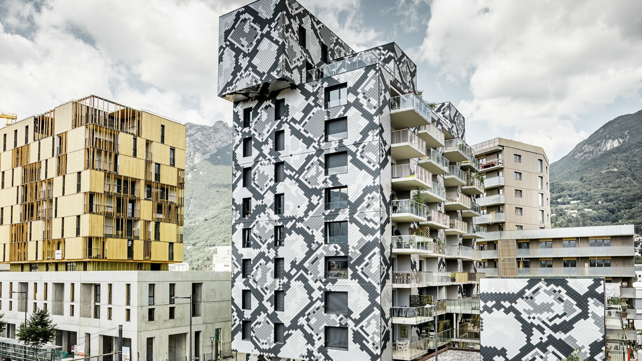 Impressive façade design on the Le Python residential building with a snake pattern. The façade was created using the PREFA rhomboid façade tiles in anthracite, light grey, plain aluminium and metallic silver.