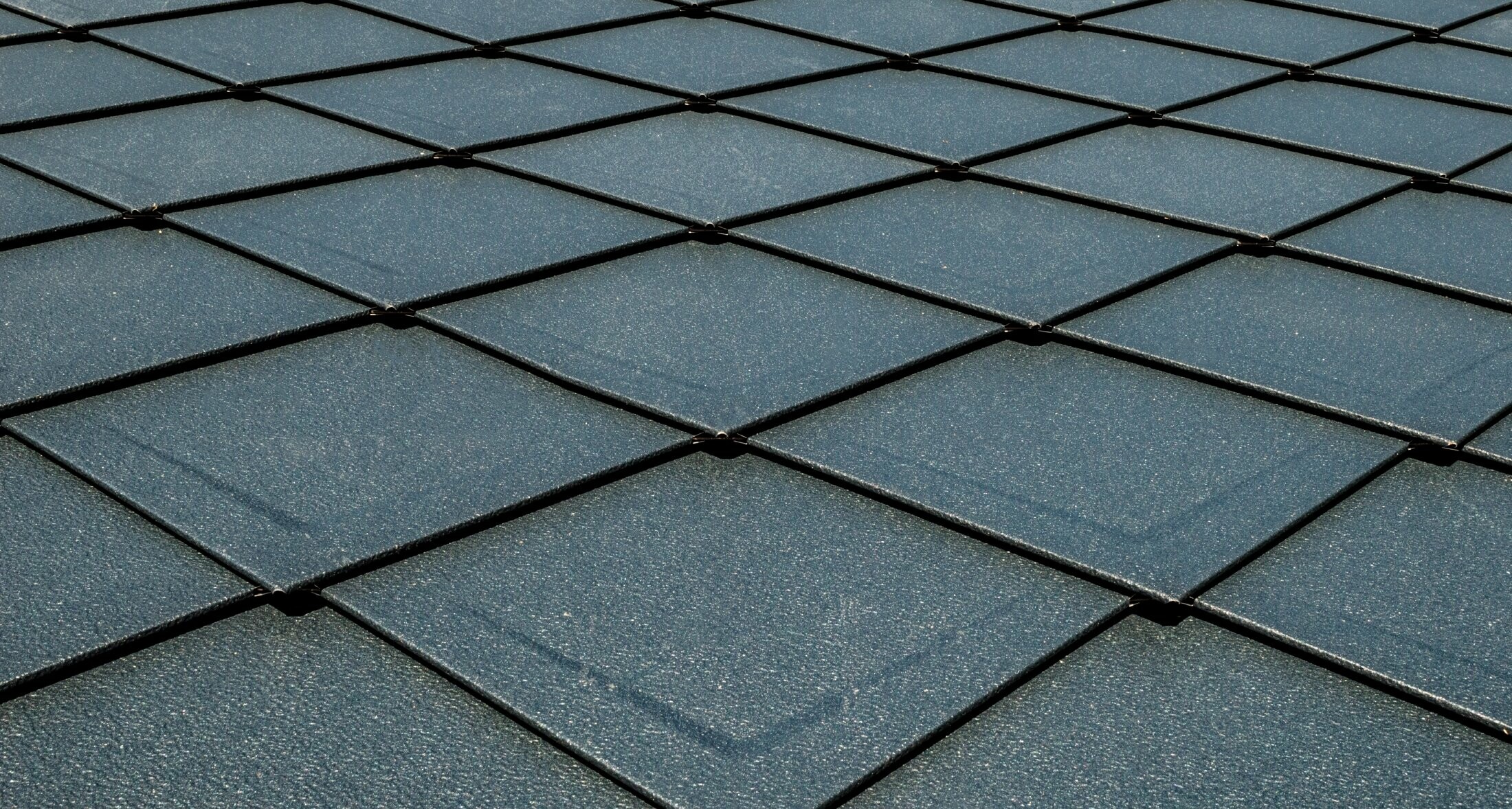 PREFA rhomboid roof tiles 29 × 29 in P.10 anthracite with beading installed as a surface, roof with scaly appearance