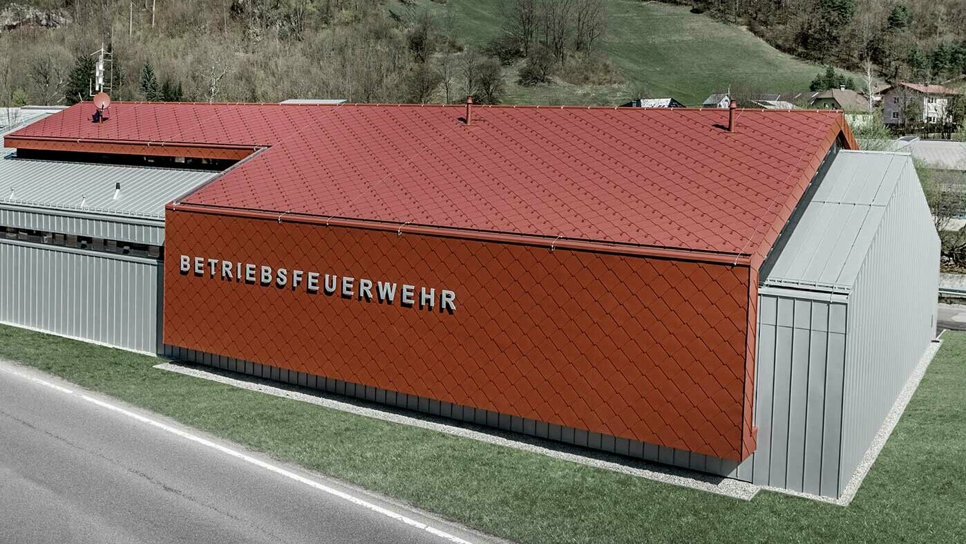 The new fire station for PREFA and Neuman Aluminium’s own fire brigade was clad with the new 44 × 44 rhomboid roof and wall tiles in P.10 oxide red and Prefalz in metallic silver.