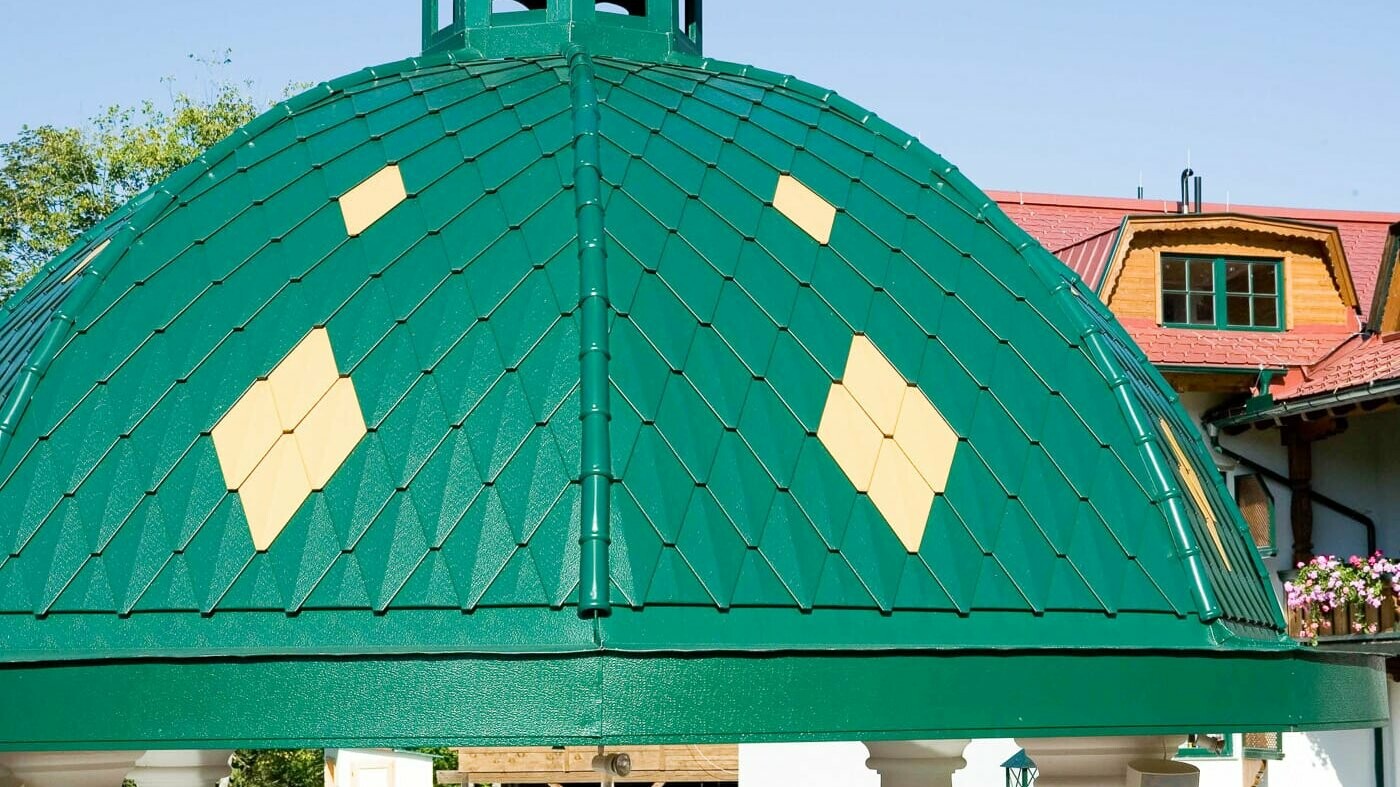 Round dome covered with PREFA’s small rhomboid tile in moss green