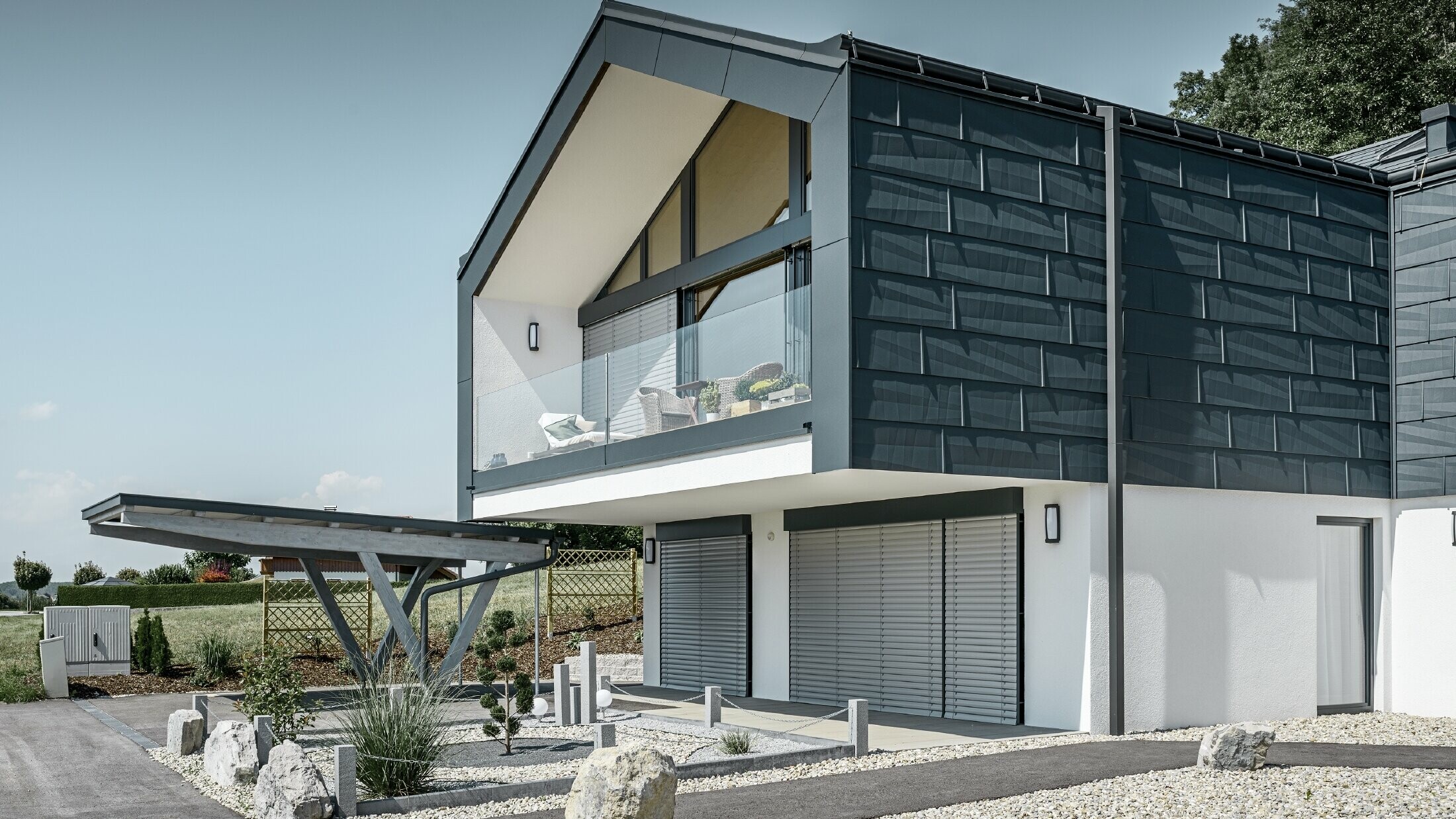 Modern apartment building with a large glass front, roof and façade were clad in the PREFA roof and façade panel FX.12 in anthracite