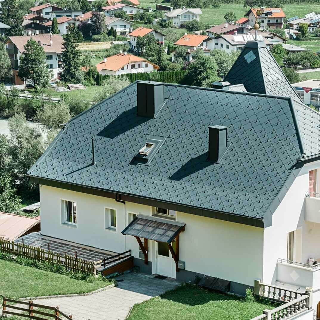 Half-hip roof with a tower, covered with the 44 × 44 aluminium rhomboid roof tiles in anthracite.