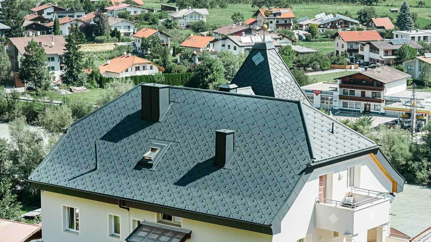 Half-hip roof with a tower, covered with the 44 × 44 aluminium rhomboid roof tiles in anthracite.