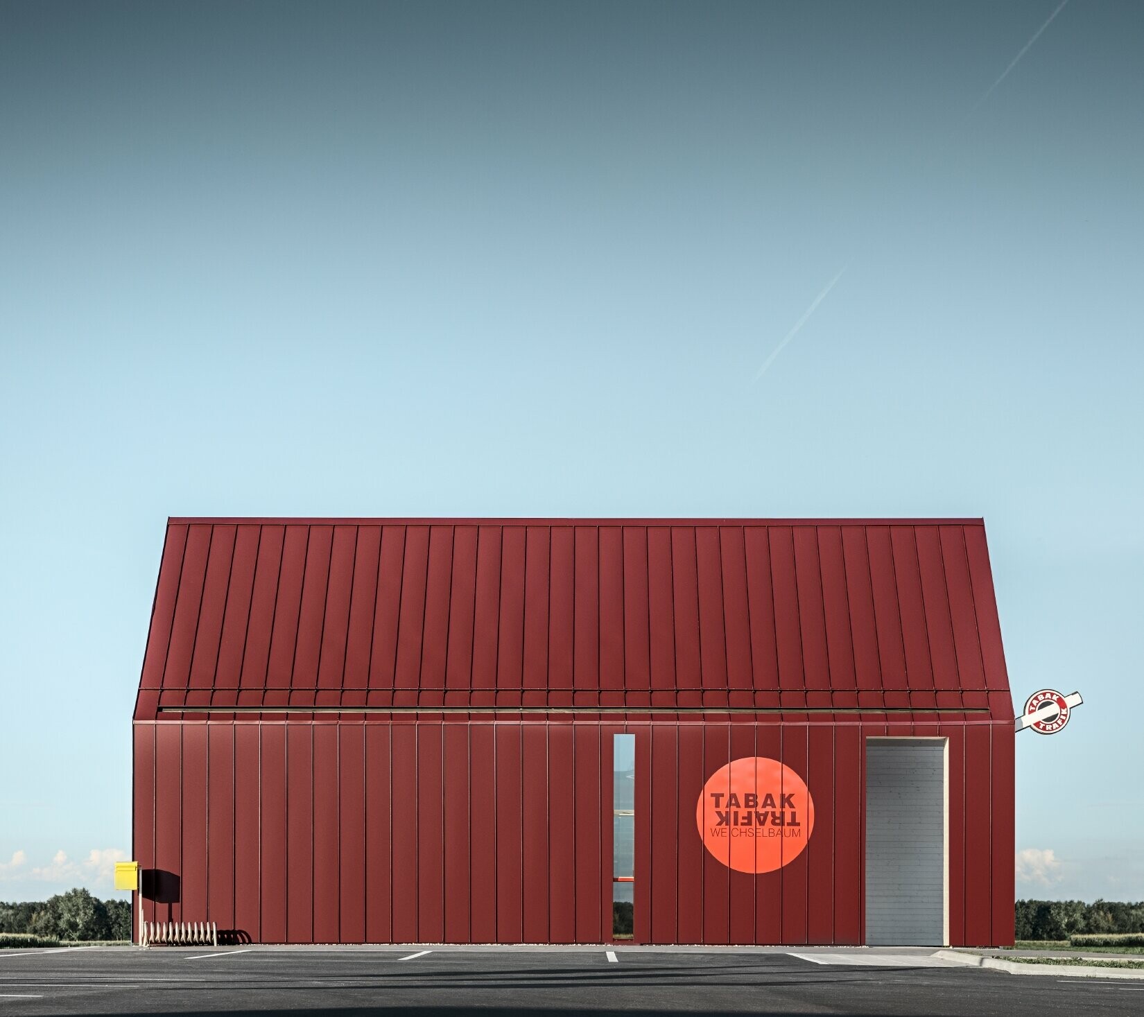 Modern tobacconist with gable roof (without overhanging eaves) and an aluminium coating by PREFA with standing and single lock standing seam in the special colour of black red