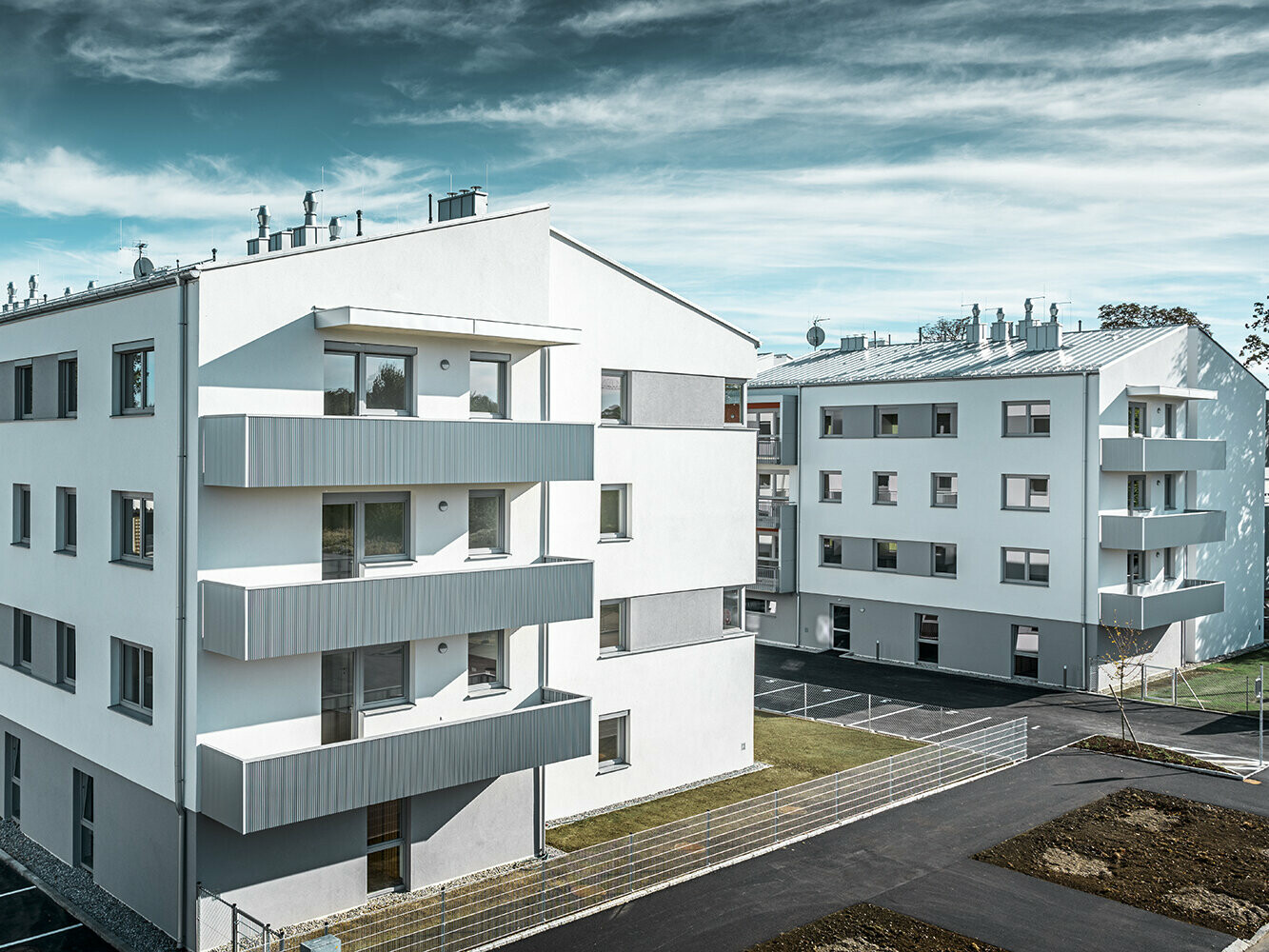 Modern apartment complex with white façade and balconies with PREFA serrated profile in metallic silver