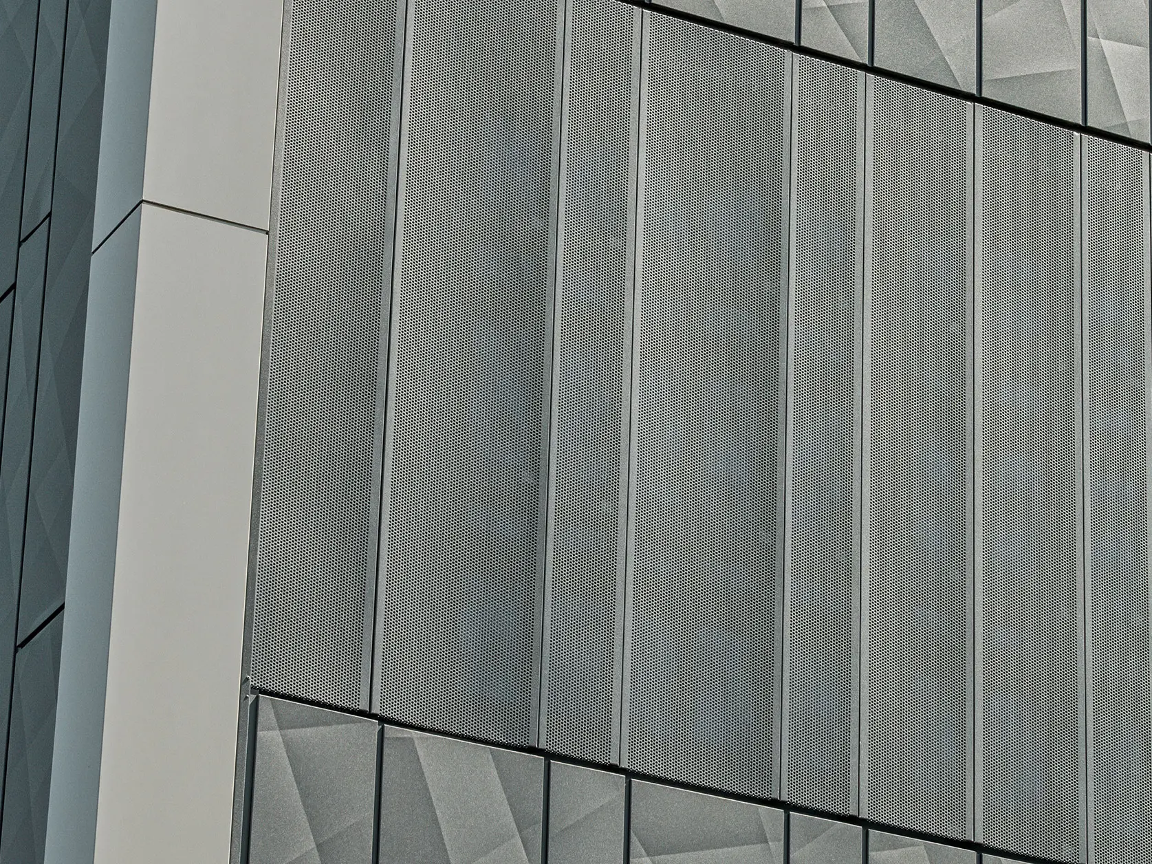 Facade view of a Eurospar supermarket in Rohrbach with PREFA Siding.X and perforated sidings in anthracite. The Siding.X elements feature a lively, geometric joint pattern, while the perforated Sidings offer a modern, air-permeable structure.