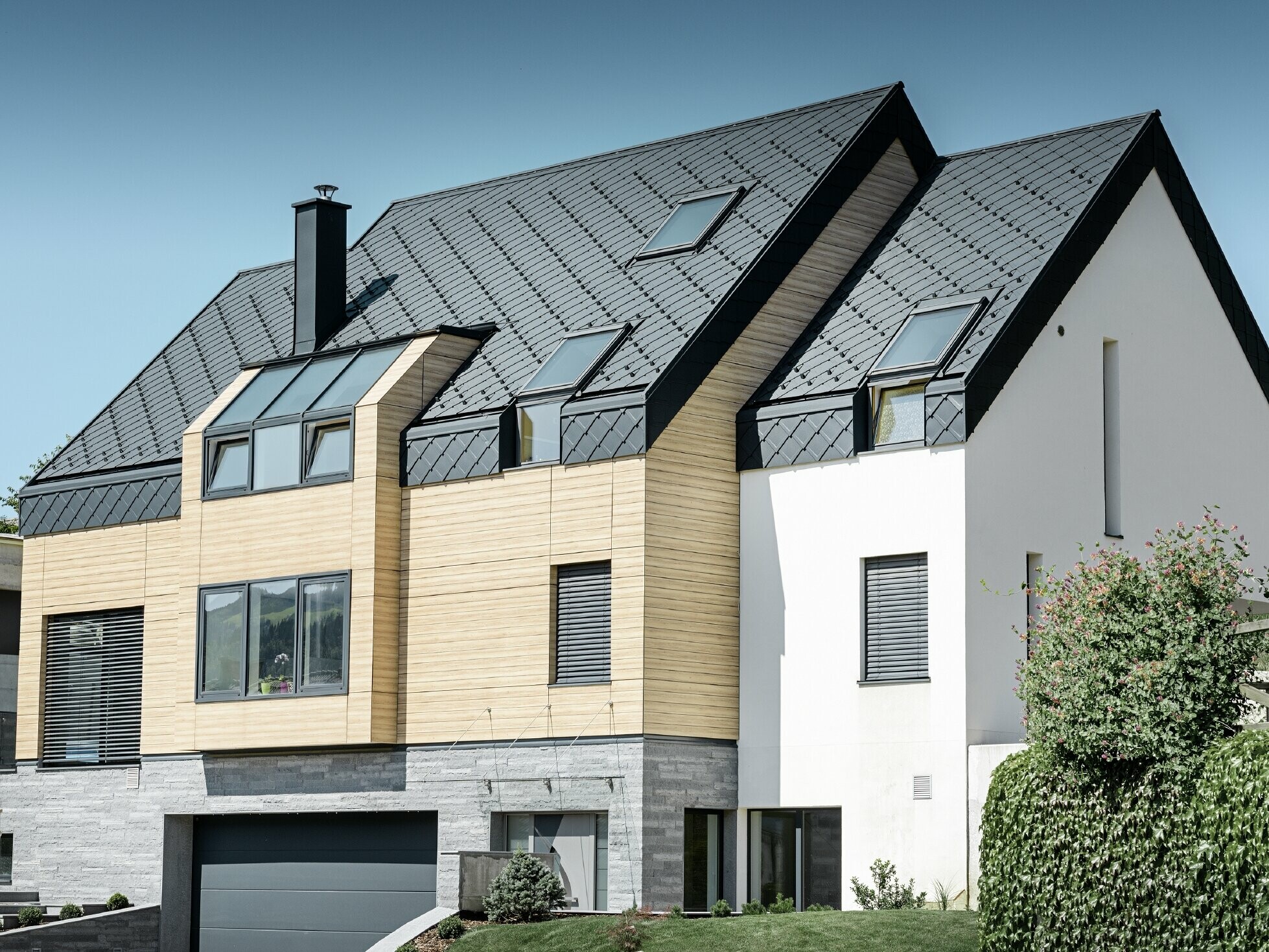 Contemporary new building, where the roof covering also extends over the upper part of the façade, aluminium rhomboid roof tiles in anthracite were used as roof cladding