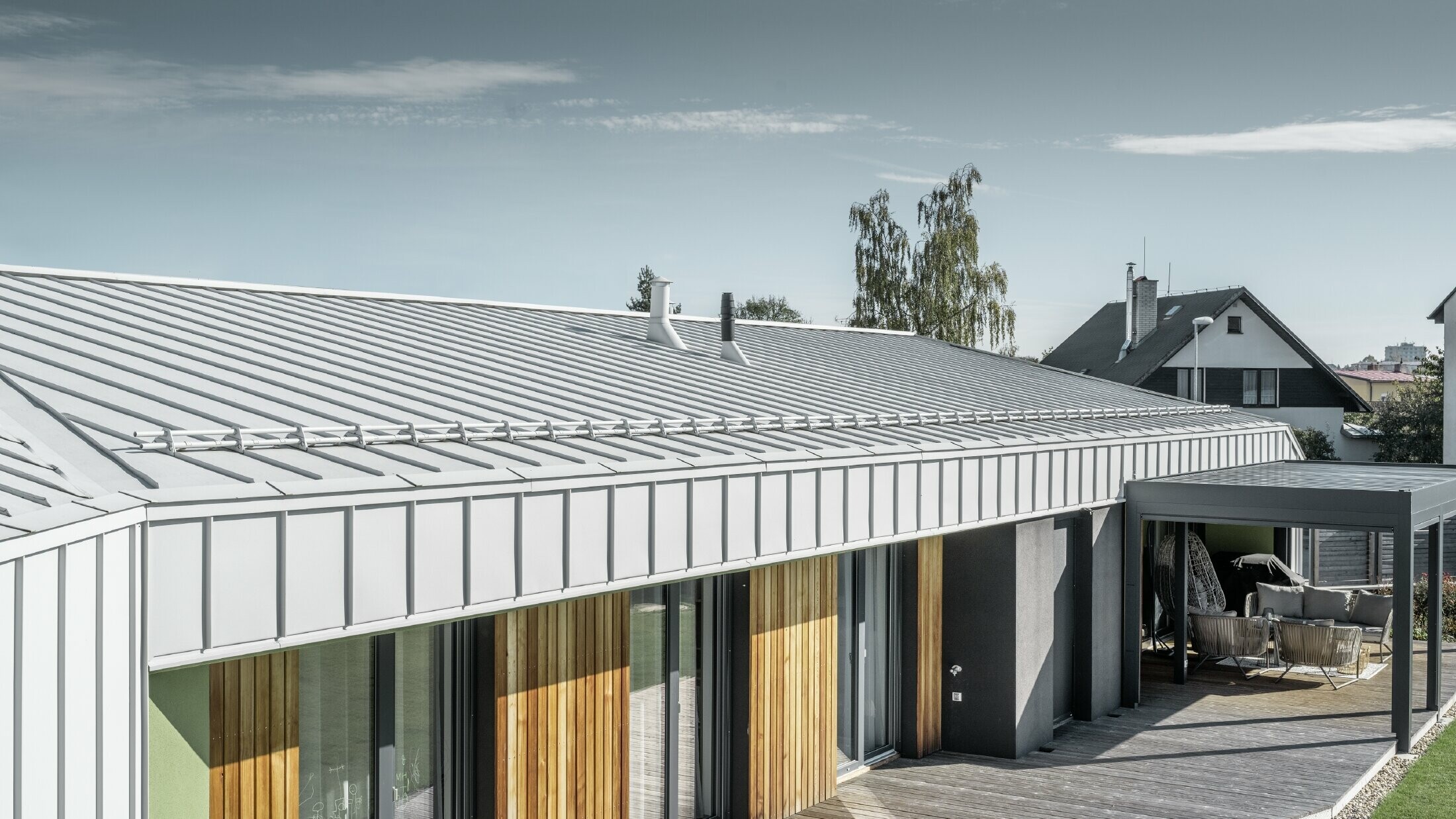 Bungalow with PREFALZ roof and façade in PREFA white and wooden terrace