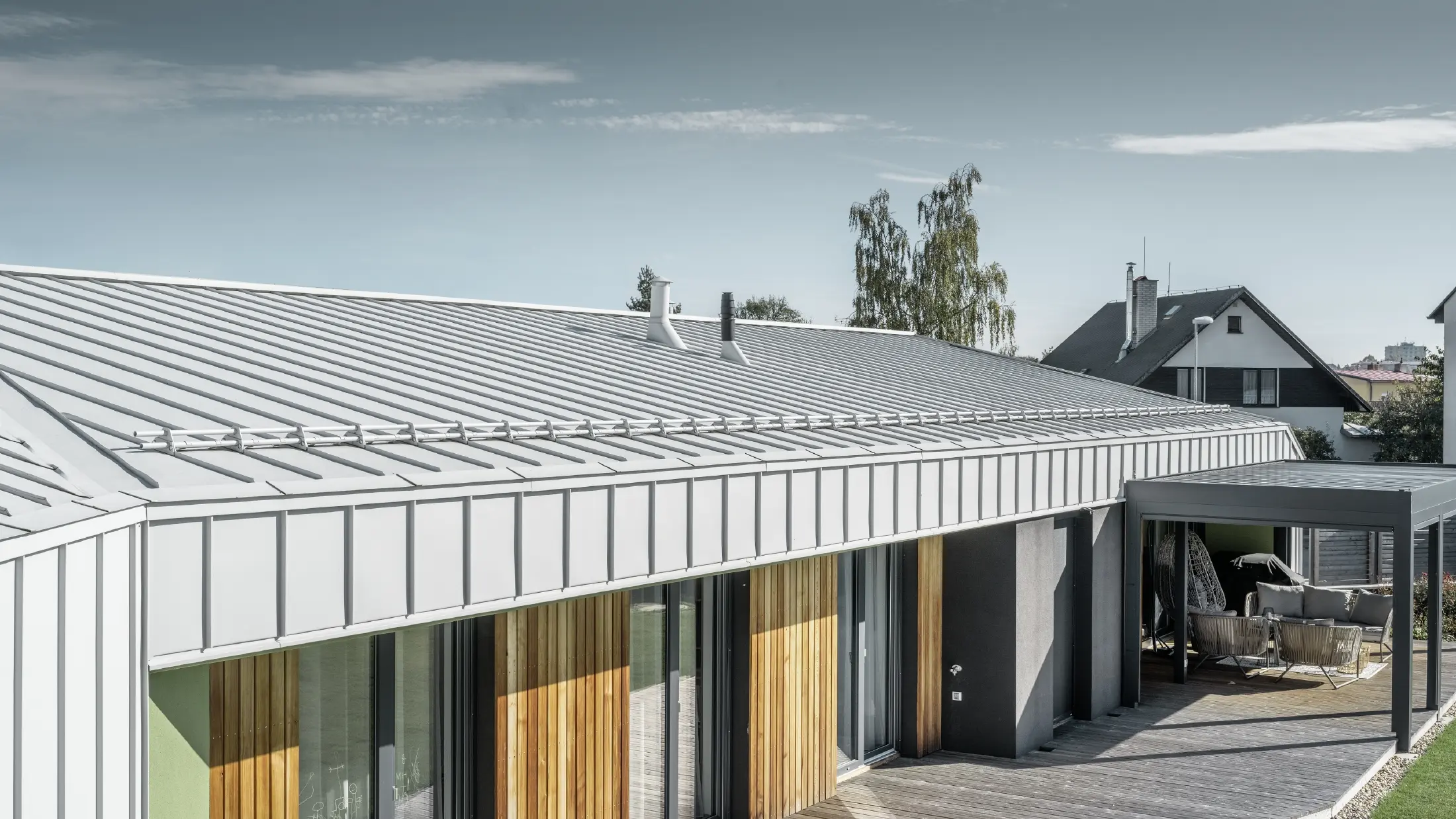 Bungalow with PREFALZ (standing seam) roof and façade in PREFA white and wooden terrace