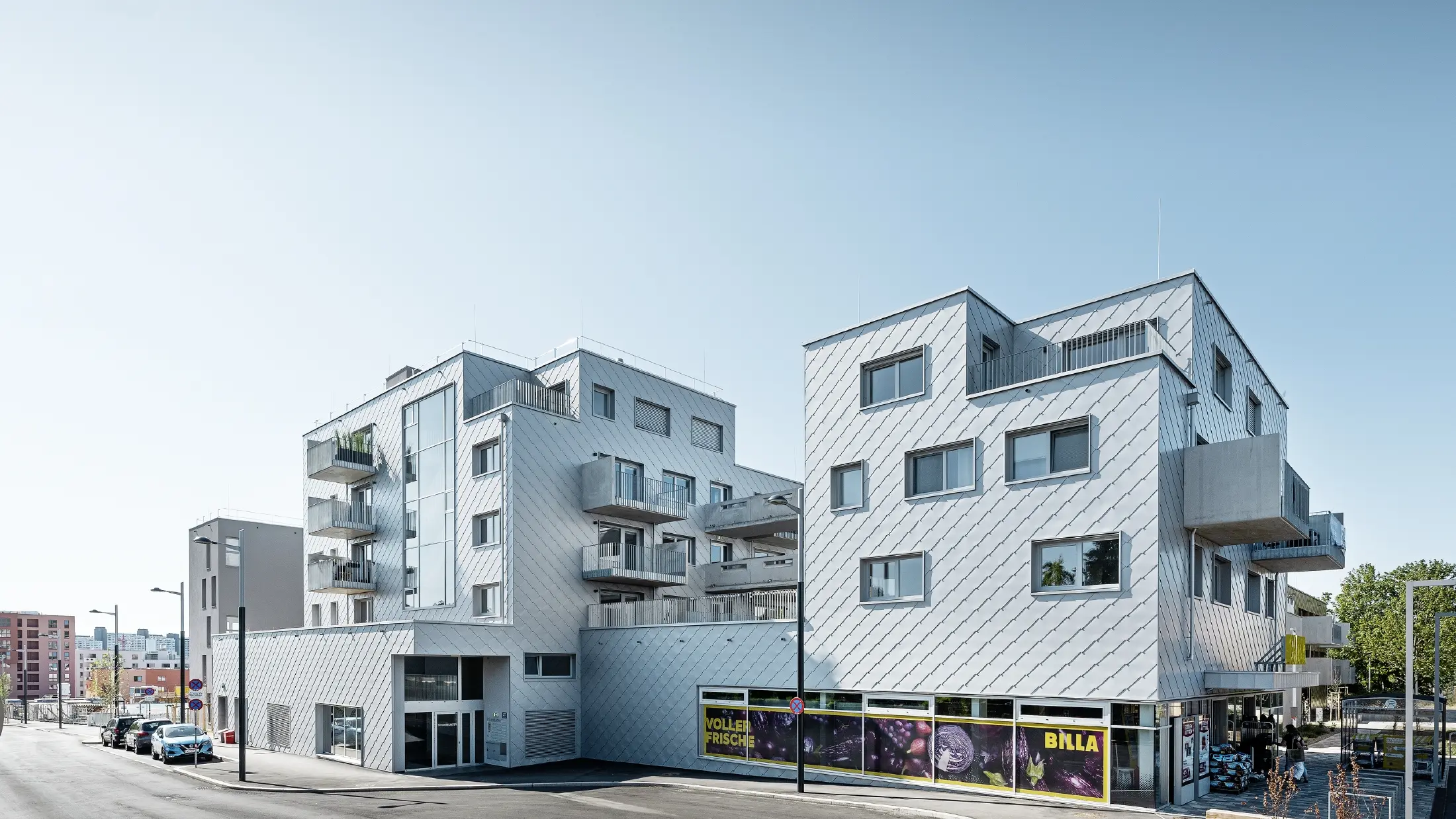Apartment complexes with flat roof and rhomboid cladding on the façade with PREFA 44 × 44 rhomboid façade tiles in metallic silver